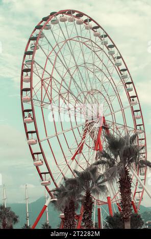 Part of a vintage retro Ferris wheel carousel against the background of the sky in emerald toning. Stock Photo