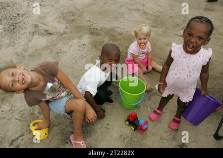 A group of small children take time out from playing in the sand to pose for the camera. Subjects: Children; Recreation; Wildlife refuges. Location: North Carolina. Fish and Wildlife Service Site: ALLIGATOR RIVER NATIONAL WILDLIFE REFUGE.  . 1998 - 2011. Stock Photo