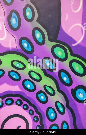 Abstract purple graffiti with a swirling wavy pattern and blue-yellow circles. Stock Photo