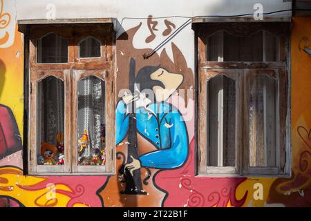 August 07, 2022. Georgia. Batumi. Streets of the city.Graffiti musician with cello on the wall in the old city of Batumi. Stock Photo