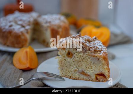 Pieces of cake decorated with persimmons Stock Photo