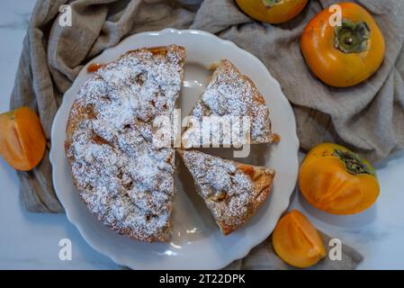 Pieces of cake decorated with persimmons Stock Photo
