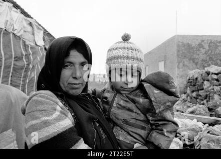 Palestine, Kisan: A mother holds her son in front of the ruins of her home at the end of first intifada (1992) Stock Photo