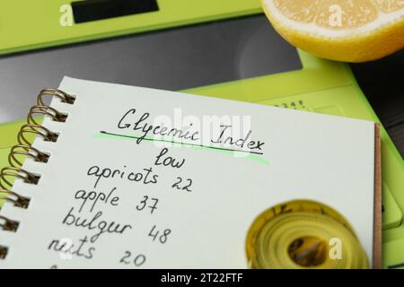 Notebook with products of low glycemic index, calculator, measuring tape and lemon, closeup Stock Photo