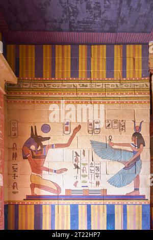 Ancient Egyptian mural depicting two figures, one with the head of a jackal representing the god Anubis and the other with the head of a cow represent Stock Photo