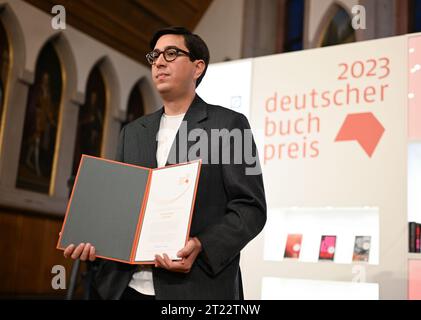 16 October 2023, Hesse, Frankfurt/Main: Austrian author Tonio Schachinger holds the certificate after being awarded the 2023 German Book Prize for his novel 'Endzeitalter. The prize for the best German-language novel of the year is awarded annually at the start of the Frankfurt Book Fair. Photo: Arne Dedert/dpa Stock Photo