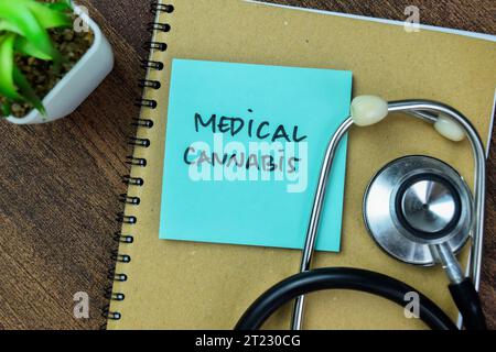 Concept of Medical Cannabis write on sticky notes with stethoscope isolated on Wooden Table. Stock Photo