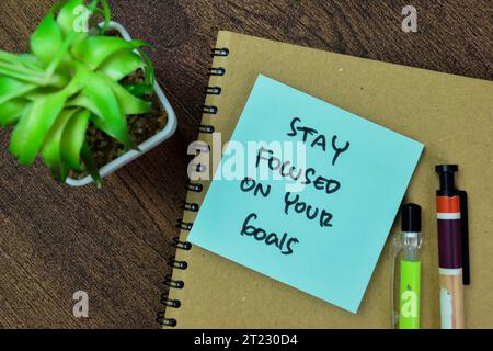 Concept of Stay Focused on Your Goals write on sticky notes isolated on Wooden Table. Stock Photo