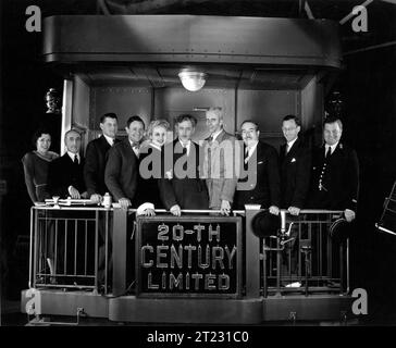 CAROLE LOMBARD, JOHN BARRYMORE and Director HOWARD HAWKS with members of the cast (left to right) Dale Fuller,, Etienne Giradot, Ralph Forbes, Roscoe Karns, Carole Lombard, John Barrymore, Howard Hawks, Walter Connolly,Charles Lane and James B. Burtis on the set of TWENTIETH CENTURY 1934 Screenplay BEN HECHT and CHARLES MacARTHUR Columbia Pictures Stock Photo
