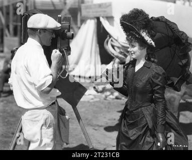 IRENE DUNNE being photographed by still photographer FRED HENDRICKSON on the set of CIMARRON 1931 in which she co-starred with RICHARD DIX Director  WESLEY RUGGLES Novel EDNA FERBER Costume Design MAX REE Music MAX STEINER RKO Radio Pictures Stock Photo