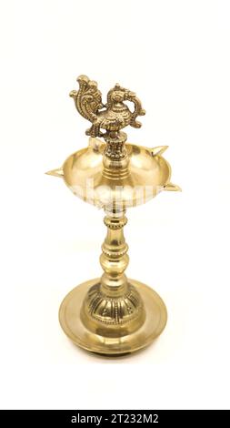 a vintage indian samai or vilakku, an oil lamp with a peacock bird emblem used to light fire and pray to god during religious events and rituals Stock Photo