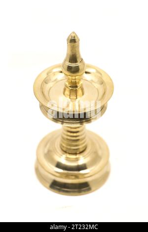 traditional gold oil lamp or vilakku or samai with a clean shiny surface used as antique decoration and for religious ceremonies isolated Stock Photo