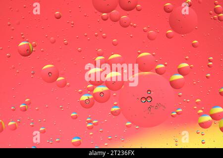 Macro photo with circles oil droplets water surface. Abstract yellow and red background with oil bubbles Stock Photo
