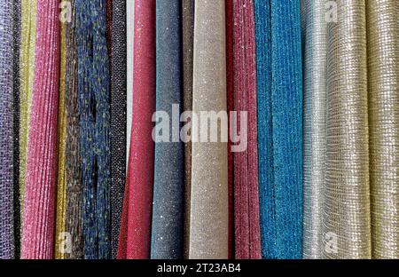 multi-colored curtains in the store. texture of multi-colored fabrics, close up. samples of multi-colored fabric close-up. multi-colored fabric hangin Stock Photo
