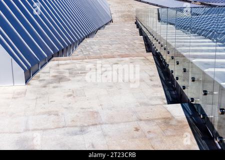 Shiny roof made of stainless steel plates, handrails and stone stairway going down. Abstract modern architecture background photo Stock Photo