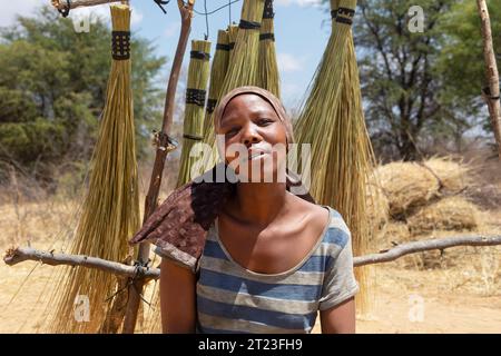 entrepreneur african woman in the village , selling brooms on the side of the highway to the cars passing by Stock Photo