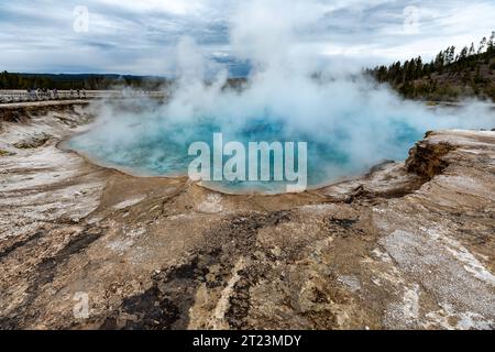 Steam rises from deep blue pool of hot spring Stock Photo