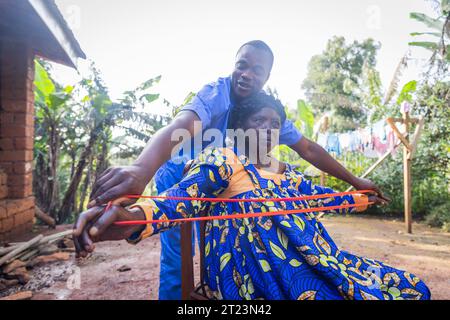 Young physiotherapist helping an old woman to exercise with a resistance band Stock Photo