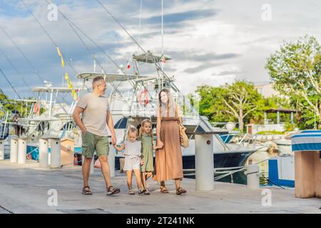 A happy, mature couple over 40 with their two daughters enjoying a leisurely walk on the waterfront, their joy evident as they embrace the journey of Stock Photo