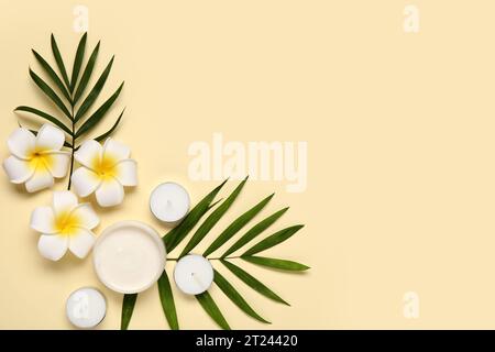 Composition with jar of cream, candles, palm leaves and flowers on color background Stock Photo