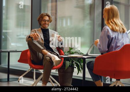 Two diverse business colleagues working together on project sitting in modern coworking Stock Photo