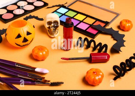Composition with decorative cosmetics, makeup brushes and Halloween decorations on color background Stock Photo