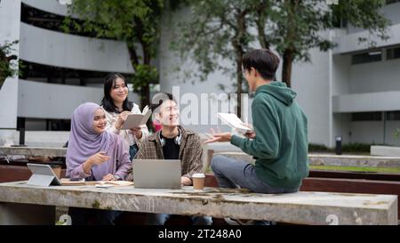 A smart and cheerful young Asian male college student in a green hoodie is helping his friends with math, tutoring and preparing for the exam in a cam Stock Photo