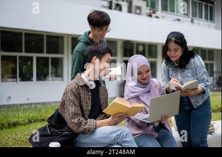 A group of cheerful diverse Asian university students is talking and sharing their ideas for a group project, working together outdoors. University li Stock Photo