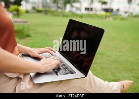 Closeup image of businesswoman working on laptop in city park Stock Photo
