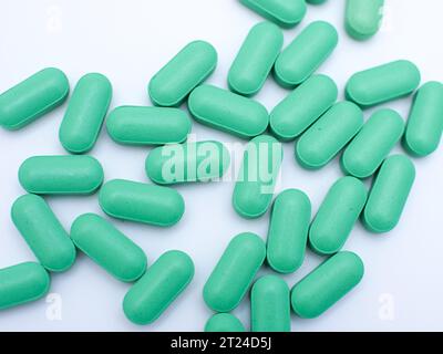 green medical pills and tablets scattered isolated on white background Stock Photo