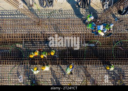 Construction workers worak at the Matarbari Power Plant is a 1,200-megawatt (2x600) coal-fired power station under construction in Maheshkhali Upazila Stock Photo