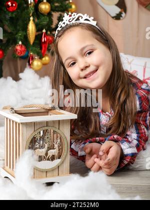 Beautiful little girl in front of christmas tree Stock Photo