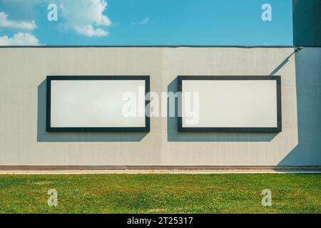 Two blank advertising billboards on the wall as mockup posters and design element Stock Photo