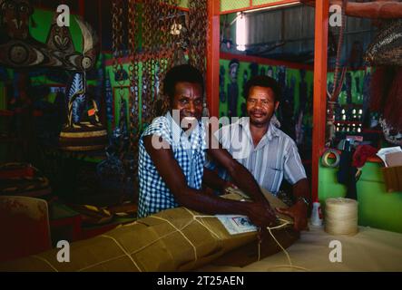 Papua New Guinea. Local men in craft shop. Stock Photo