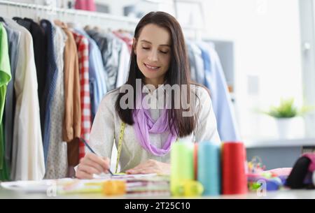 Woman write wonderful idea, realize it in fashion industry, professional atelier Stock Photo