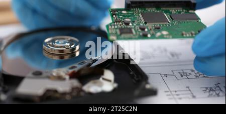 Male technician hold computer details, try to fix or collect device, dvd disc Stock Photo