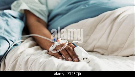 Iv drip, emergency and hand of patient in a hospital after surgery, treatment and operation in a clinic sleeping. Closeup, healthcare and person in Stock Photo