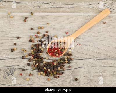different kinds of dry pepper in spoons on wooden table Stock Photo