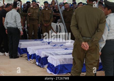 Gan Yavne, Israel. 17th Oct, 2023. Soldiers and relatives stand by the coffins of members of the Israeli Kutz Family, Aviv, 54 years old, Livnat, 49 years old, Rotem, 19 years old, Yonatan, 17 years old, and Yiftach, 15 years old, during their funeral in Gan-Yavne. Kutz Family members were murdered in their home by Palestinian militants who infiltrated into the Israeli Kibbutz of Kfar Aza last week. Credit: Ilia Yefimovich/dpa/Alamy Live News Stock Photo