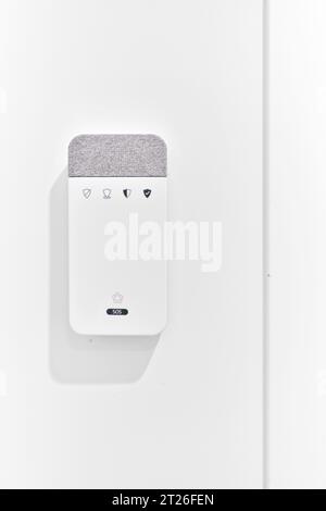 Close up of contemporary alarm equipment, security panel mounted on wall in modern house against white copy space wall. Security, safety, smart home c Stock Photo