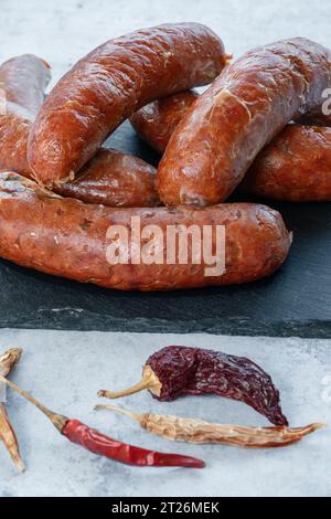 This photo shows a Nduja sausage on a black slate from a front view after being cooked. Stock Photo