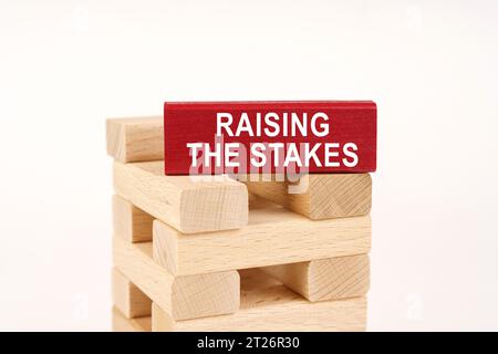 Business concept. On the wooden planks there is a red one with the inscription - Raising The Stakes Stock Photo