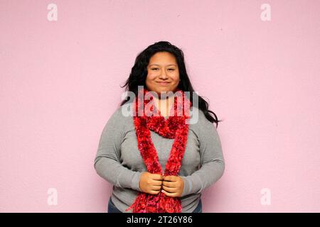 Young fat latin woman with overweight body positive is happy and naturally happy with her body with gray sweater and red scarf Stock Photo