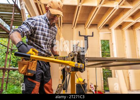 Sheet Metal Folding Machine Operating by Caucasian Construction Worker in His 40s Stock Photo