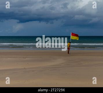 Downhill Strand, Downhill, County Londonderry, Northern Ireland July 05 2023 - Lifeguard placing a safe swimming flag on the beach Stock Photo