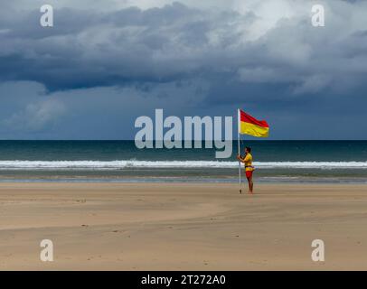 Downhill Strand, Downhill, County Londonderry, Northern Ireland July 05 2023 - Lifeguard placing a safe swimming flag on the beach Stock Photo