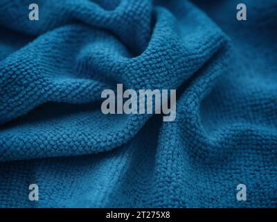 A dark blue microfiber cleaning towel texture background. Low key. Close up. Stock Photo