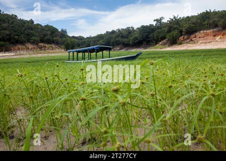 Boat stranded on dry river in extreme drought in the Amazon Rainforest, the largest tropical forest in the world. Concept of climate change, global. Stock Photo