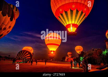 Hot air Balloons rise into the early morning sky, before sunrise from the Hot air balloon Take Off Site in Luxor Stock Photo