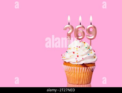 Birthday Cake With Candle Question Mark And Number 69 - On Pink Background. Stock Photo